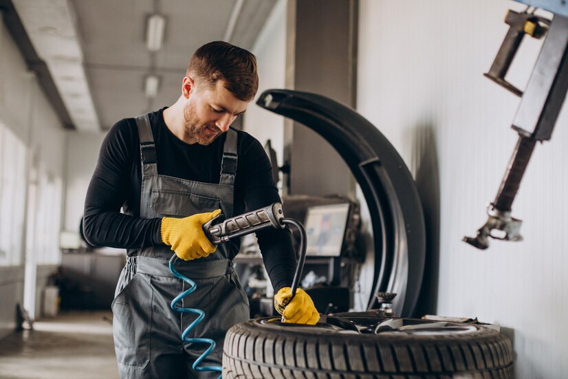 car-mechanic-changing-wheels-car_1303-27467