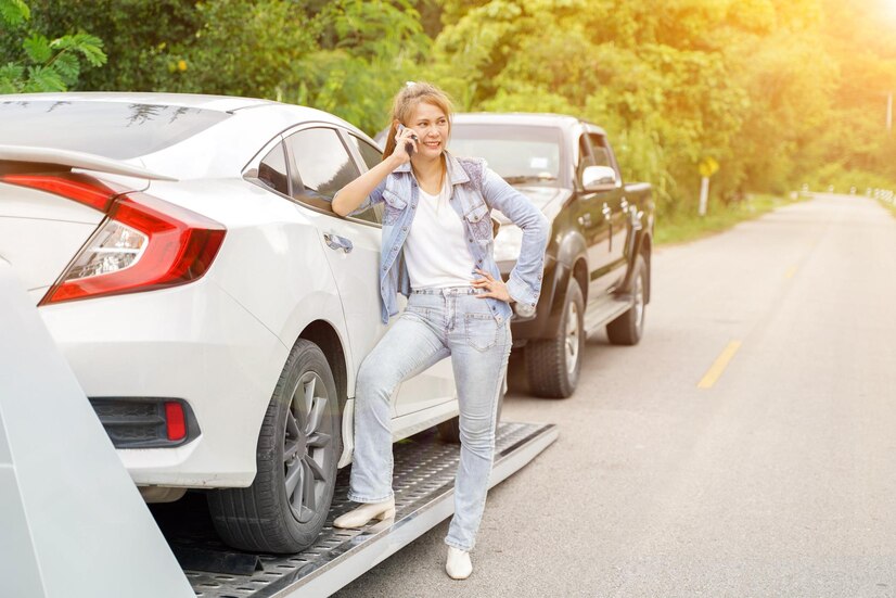 young-woman-making-phone-calling-someone-while-towing-service-helping-her-country-road-with-sun-flare-roadside-assistance-concept_36555-1209